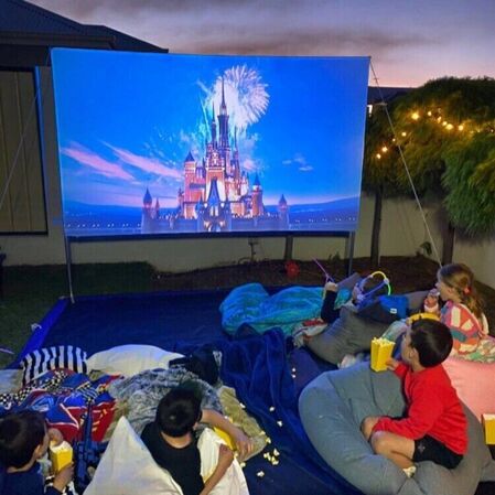 Children watching an outdoor cinema hired in Perth.