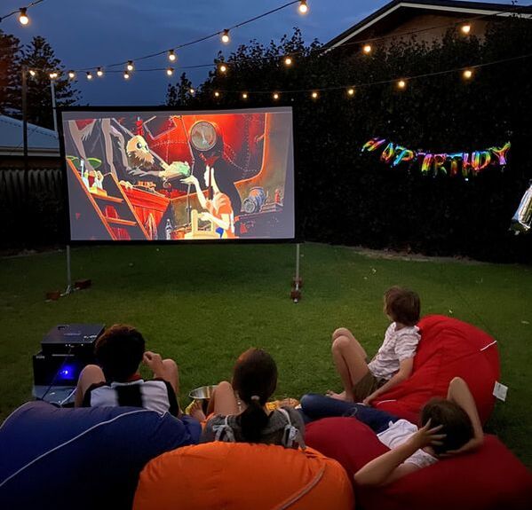 Children watching an outdoor cinema hired in Perth.